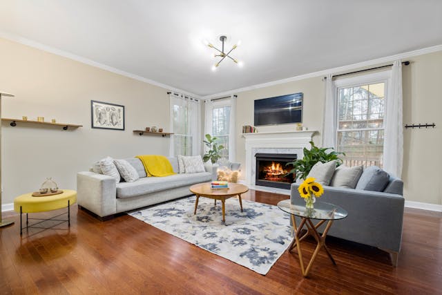 a living room with two grey couches and a fire place